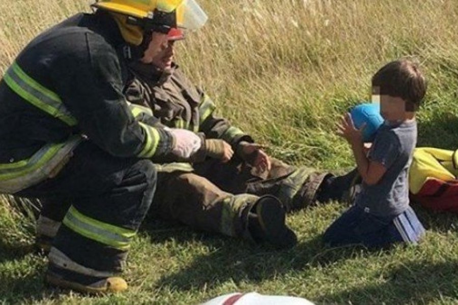 Conmovedora imagen de dos bomberos que distraen a un nene tras un accidente